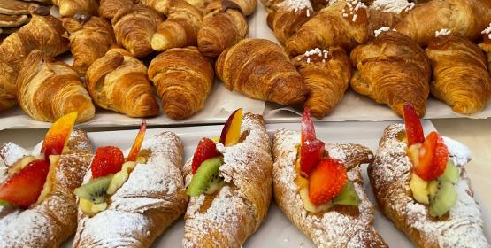 Deliziosi cornetti assortiti con frutta fresca e zucchero a velo.
