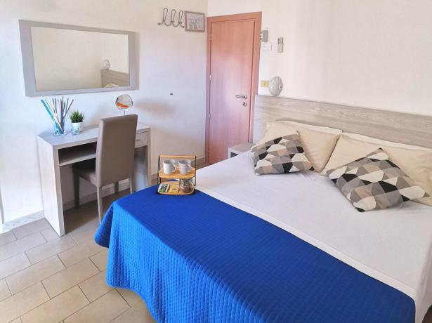 Camera accogliente con letto matrimoniale, TV, scrivania e decorazioni moderne.