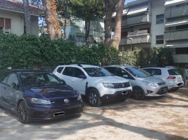 Parking lot with cars in front of residential buildings.
