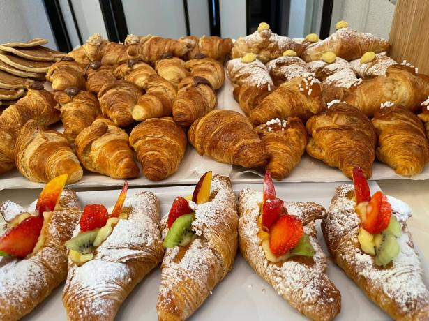 Delicious assorted croissants with fresh fruit and powdered sugar.